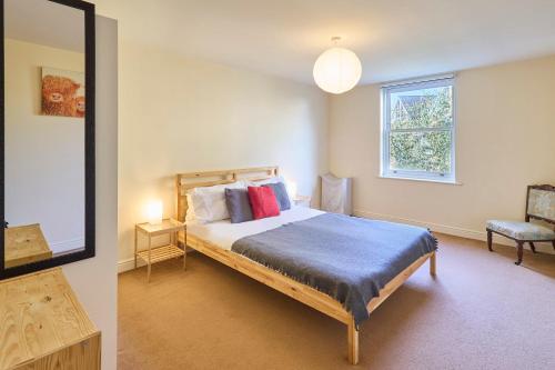 a bedroom with a bed and a mirror and a chair at Host & Stay - Bingley Court in Canterbury