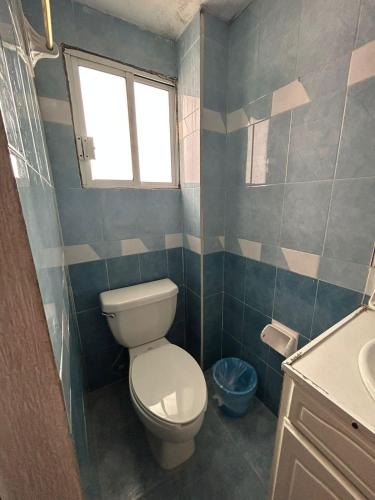 a bathroom with a toilet and a sink and a window at Hotel Capri Playa a una calle de la Playa Regatas in Veracruz