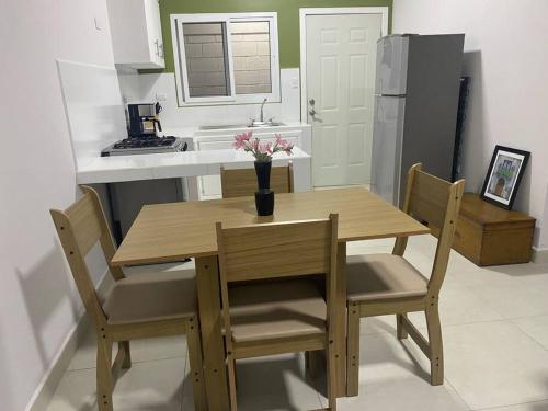 a kitchen with a wooden table and chairs and a kitchen with a refrigerator at Céntrico Apartamento in Santa Rosa de Copán
