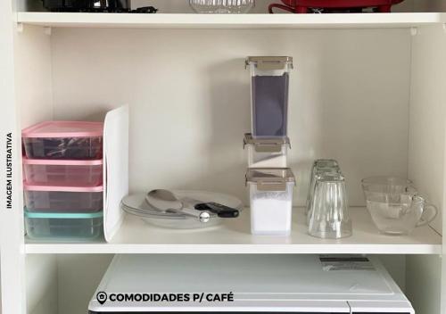 a white shelf with various kitchen items on it at APARTAMENTO ENCANTADO V. MARIA 9 in Foz do Iguaçu