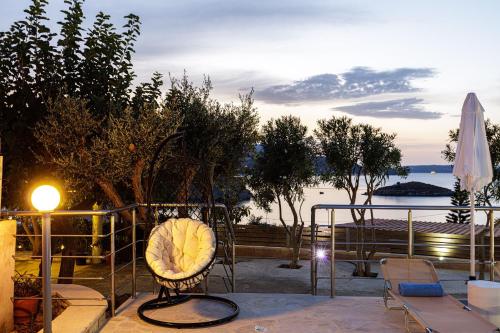 a chair on a balcony with a view of the water at Villa THAMI in Almirida