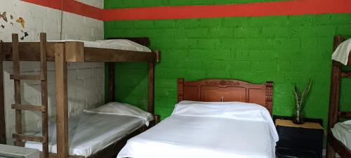 1 dormitorio con 2 literas y una pared verde en Tayrona Shalom Bait, en Santa Marta