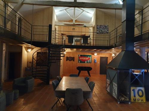 a room with a table and chairs and a spiral staircase at exceptionnel loft style industriel tout équipé 15 personnes avec piscine et jacuzzi in Villebramar