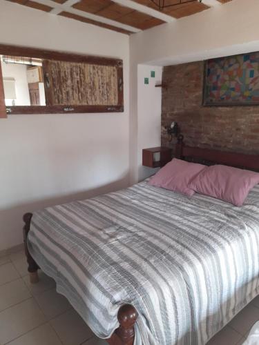a bedroom with a bed and a brick wall at Departamento Reconquista in Villa María