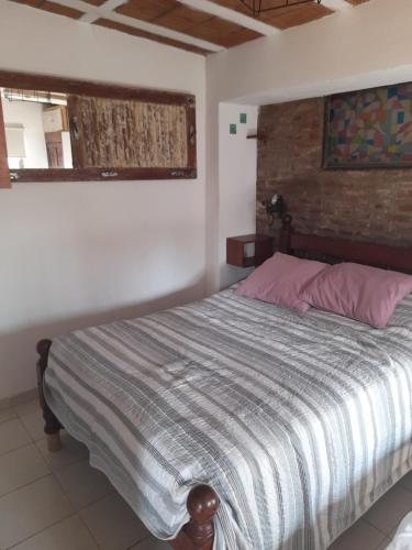 1 dormitorio con cama y pared de ladrillo en Departamento Reconquista en Villa María