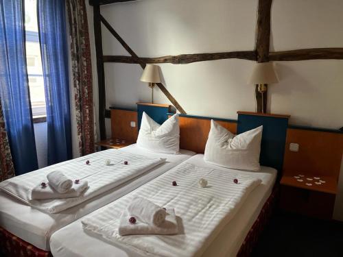 two beds in a hotel room with towels on them at Hotel zur Brücke in Herzogenrath