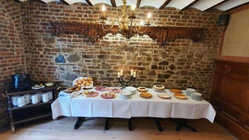 a table with pastries on it in a brick room at Hotel zur Brücke in Herzogenrath