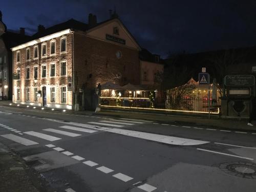 un edificio iluminado en una calle de la ciudad por la noche en Hotel zur Brücke, en Herzogenrath