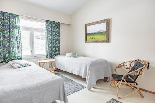 ピュハトゥントゥリにあるLucky Lodgeのベッド2台、椅子、窓が備わる客室です。