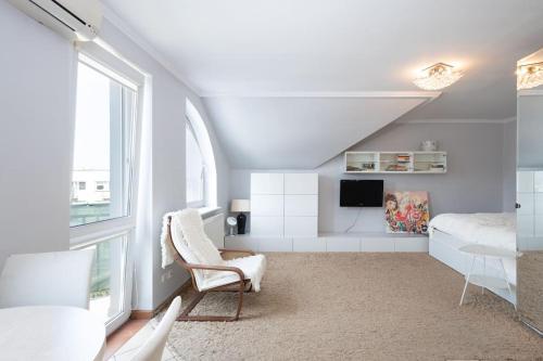 a bedroom with a bed and a chair and a window at Apartament Grójec in Grójec