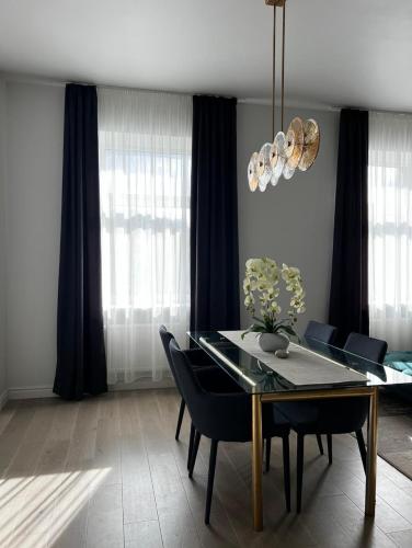 a dining room with a dining table and chairs at Raina apartment Gold in Jelgava