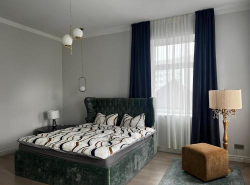 a bedroom with a large bed and a window at Raina apartment Gold in Jelgava