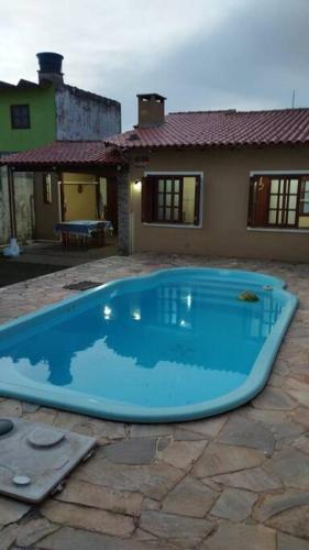 ein großer blauer Pool vor einem Haus in der Unterkunft Casa para 6 + piscina, in Rio Grande