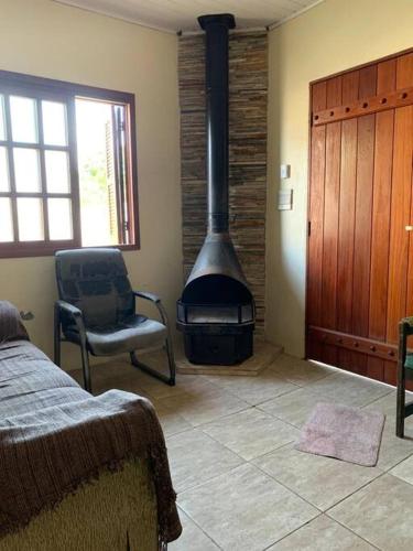 ein Wohnzimmer mit einem Holzofen im Zimmer in der Unterkunft Casa para 6 + piscina, in Rio Grande