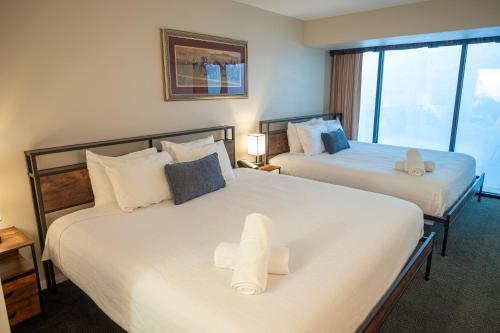a hotel room with two beds with towels on them at Stay Together Suites - Suite On The Strip Steps From Bellagio & Cosmo Sleeps 11 - NO RESORT FEE in Las Vegas