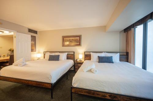 two beds sitting next to each other in a bedroom at Stay Together Suites in Las Vegas