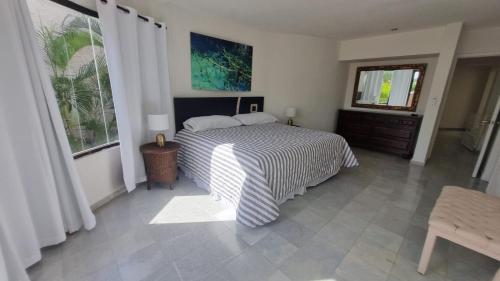 a bedroom with a bed with a striped comforter at Villas La Marina in Cancún