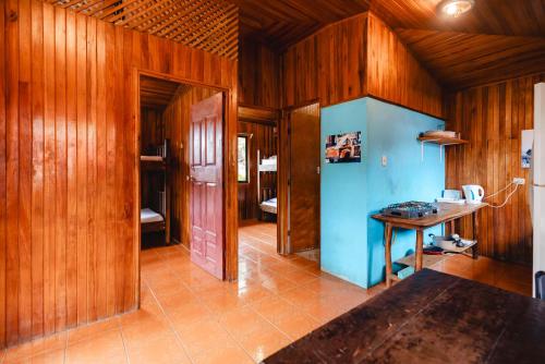 a room with wooden walls and a table in a room at Surf Paradise in Santa Teresa Beach