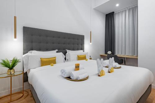 ein Schlafzimmer mit einem großen weißen Bett mit gelben Akzenten in der Unterkunft Smart Apartment Near Puerta Del Sol in Madrid