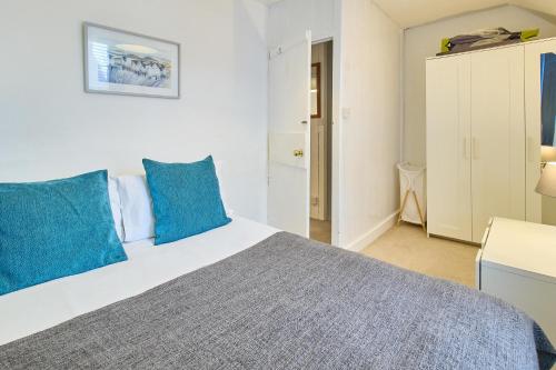 a bedroom with a large bed with blue pillows at Host & Stay - Prospect Place in Canterbury