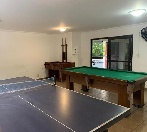 a ping pong table in a room with a ping pongetitive at Lindo Apartamento Vista mar Portaria 24h Piscina e Lazer in Guarujá