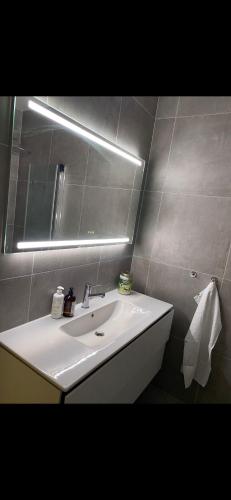 een badkamer met een witte wastafel en een spiegel bij Bogstadveien in Oslo