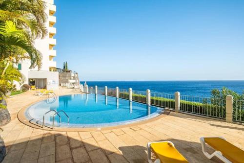 a swimming pool with the ocean in the background at Cliff in Funchal