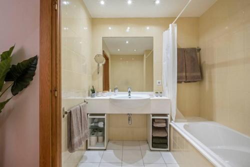 a bathroom with a white sink and a tub and a tubermott at SUPER Cliff in Funchal