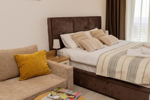 - une chambre avec un grand lit et un canapé dans l'établissement Apartman Stankovic Milmari Resort, à Kopaonik