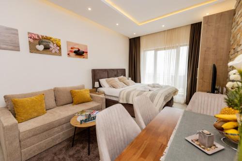 una sala de estar con un sofá y una cama en Apartman Stankovic Milmari Resort, en Kopaonik