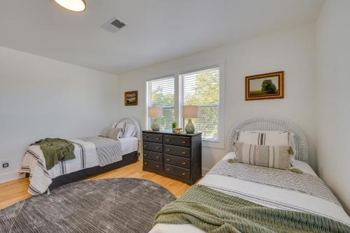 Modern Milledgeville Getaway Walk to Downtown! في ميلدغفيل: غرفة نوم بها سريرين ونافذة