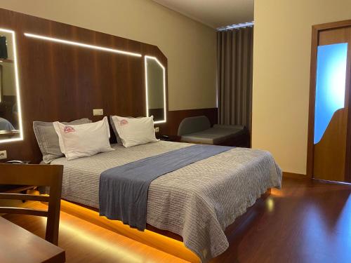 Pokój hotelowy z łóżkiem i krzesłem w obiekcie Motel Paraíso do Braseiro w mieście Vila Nova de Gaia