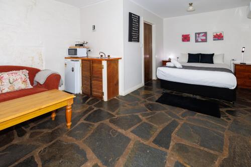 a bedroom with a bed and a couch and a table at BIG4 Cape Jervis Accommodation & Caravan Park in Cape Jervis
