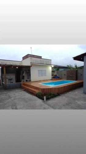 une maison avec une piscine en face de celle-ci dans l'établissement Casa com piscina perto da praia, à Caraguatatuba