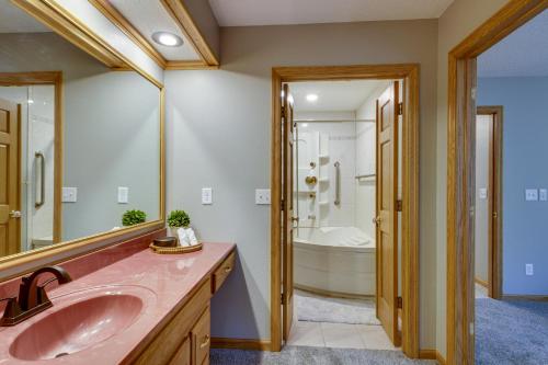 La salle de bains est pourvue d'un lavabo rose et d'une baignoire. dans l'établissement Peaceful Hibbing Getaway Heated Floors, Fire Pit!, à Hibbing