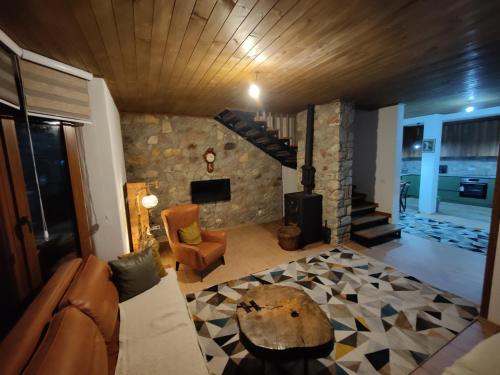 a living room with a couch and a stone fireplace at Villa Gjelbër in Prizren