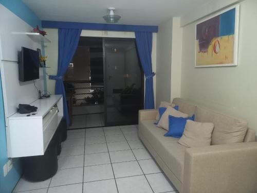 Apartamento em Fortaleza في فورتاليزا: غرفة معيشة بها أريكة وتلفزيون