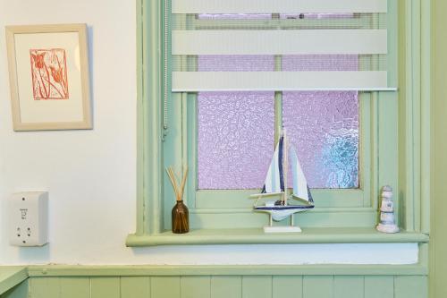 ein Fenster mit einem Spielzeugsegelboot auf einem Regal in der Unterkunft Host & Stay - The Cabin in Canterbury