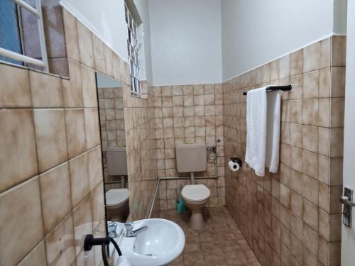 ein Badezimmer mit 2 WCs und einem Waschbecken in der Unterkunft Well Furnished and Airconditioned Rooms in Nakasero, Kampala By BoB in Kampala