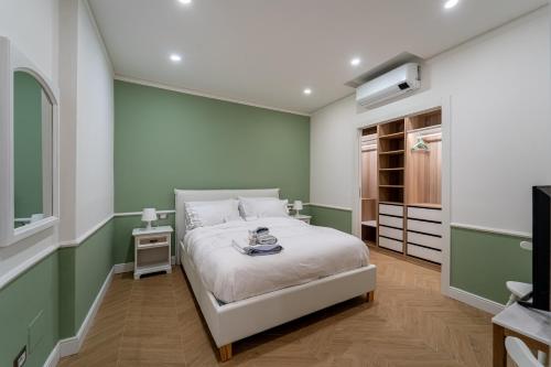 una camera da letto con pareti verdi e bianche e un letto di Duomo Guest House a Monza