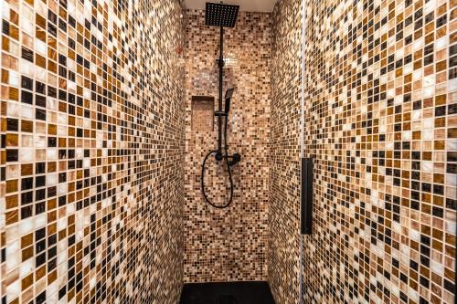 uma casa de banho com um chuveiro e paredes em azulejo em Duomo Guest House em Monza