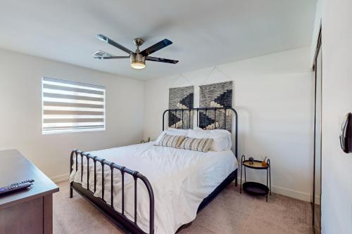 een slaapkamer met een bed en een plafondventilator bij Lone Palm Terrace in Scottsdale