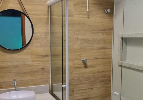 a bathroom with a mirror and a sink at Ressurgência loft in Arraial do Cabo