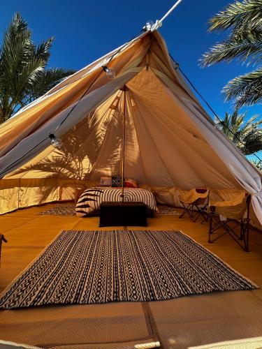 a tent with a bed in it with palm trees at High Tanks Hideaway in Wellton