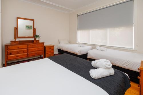 a bedroom with two beds and a mirror and a window at BIG4 Cape Jervis Accommodation & Caravan Park in Cape Jervis