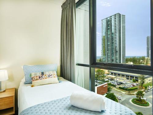 a bedroom with a bed and a large window at Broadbeach on the park 2-Bedroom in Gold Coast
