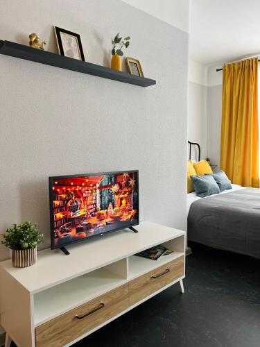 ein Wohnzimmer mit einem TV auf einem weißen Schrank in der Unterkunft Mežaparka apartamenti in Jēkabpils