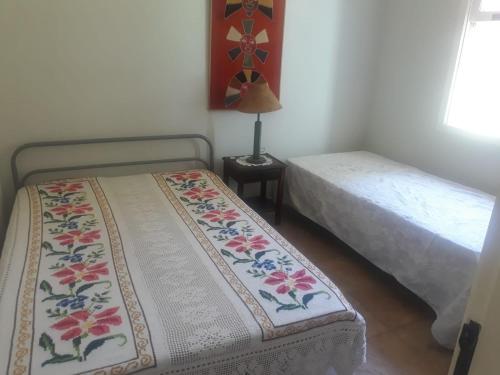 1 dormitorio con 2 camas y mesa con lámpara en Sítio Vila de Santa Barbara, en Caeté