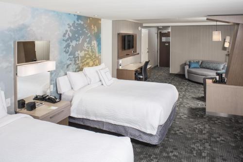 una camera d'albergo con due letti e un soggiorno di Courtyard by Marriott Albany Clifton Park a Clifton Park