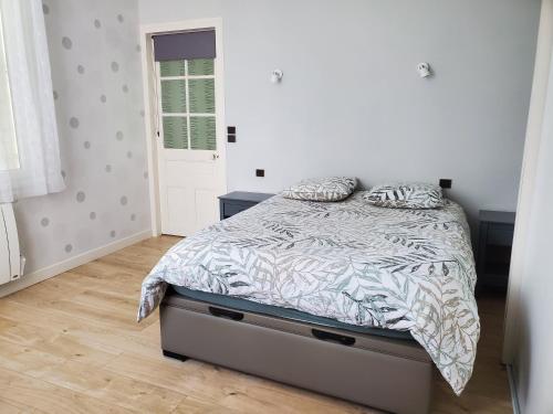 um quarto com uma cama com um edredão e almofadas em La Chamarande, peaceful cottage near Tours Amboise em Montlouis-sur-Loire
